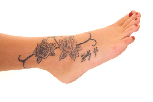 Girl with rose foot tattoo on foot
